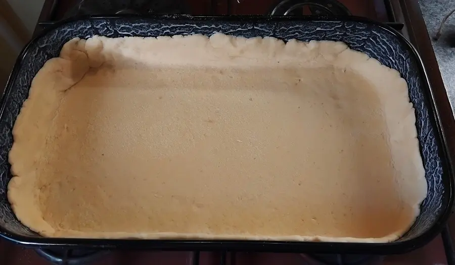 Meggyes pudingos pite első tészta tepsibe helyezése