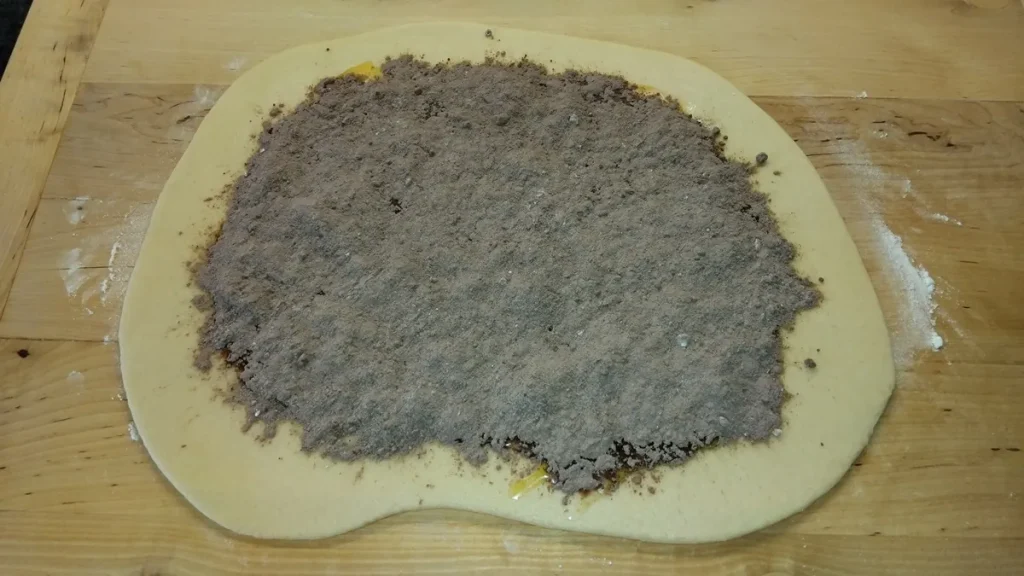 Kakaós porcukorral megszórt kelt tészta a kakaós tekercs feltekerése előtt